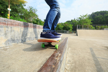 skateboarder legs riding skateboard at skatepark