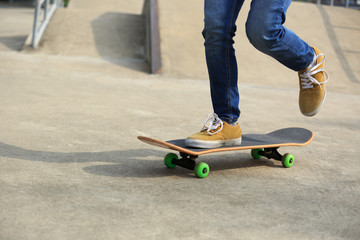 skateboarder legs riding skateboard at skatepark