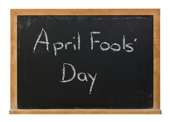 April Fools' Day written in white chalk on a black chalkboard isolated on white