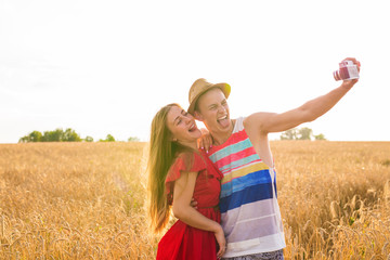 Young man and woman taking a selfie in the field