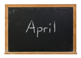 April written in white chalk on a black chalkboard isolated on white