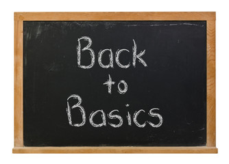 Back to basics written in white chalk on a black chalkboard isolated on white