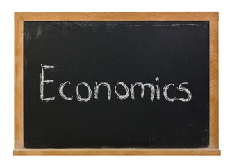 Economics written in white chalk on a black chalkboard isolated on white