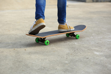skateboarder legs riding skateboard at skatepark