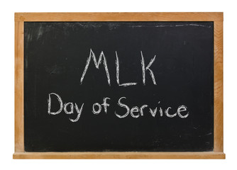 MLK Day of Service written in white chalk on a black chalkboard isolated on white
