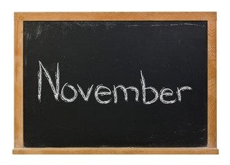 Obraz premium November written in white chalk on a black chalkboard isolated on white 