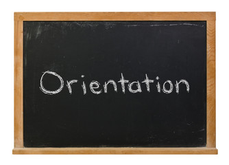 Orientation written in white chalk on a black chalkboard isolated on white
