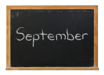 September written in white chalk on a black chalkboard isolated on white