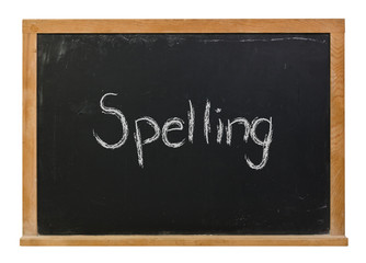 Spelling written in white chalk on a black chalkboard isolated on white