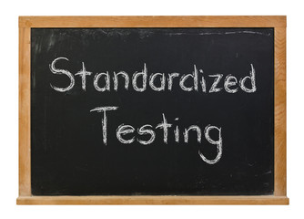 Standardized Testing written in white chalk on a black chalkboard isolated on white