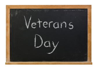 Obraz premium Veterans Day written in white chalk on a black chalkboard isolated on white
