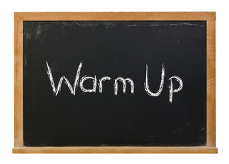 Warm up written in white chalk on a black chalkboard isolated on white