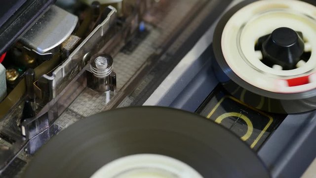 Tape recorder head and rotating reels of a cassette player. 4K, Seamless loop, Macro shot . Magnetic tape stores the music in a magnetic image