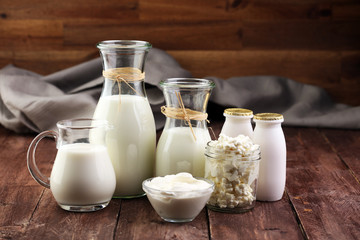 milk products - tasty healthy dairy products on a table on: sour cream in a white bowl, cottage cheese bowl, cream in a a bank and milk jar, glass bottle and in a glass