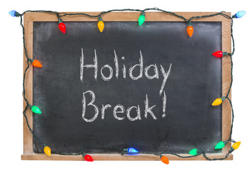 Holiday break written in white chalk on a black chalkboard surrounded with festive colorful lights...