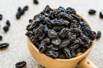 Organic Dried Raisins or Grape in wooden ladle.