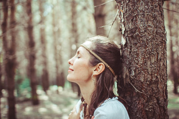 A woman is standing between trees