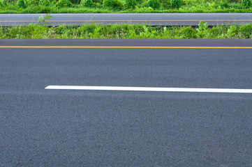 Obraz premium Empty highway with dividing line, roadside and green grass, abstract transportation background,asphalt road new construction
