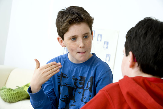 Models Do not use for HIV Young boy using cued speech to discuss with his brother affected by deafness Cued speech enables deaf persons to receive the langue by sight ; it was set up in the US by the doctor R Orin Cornett in 1967 The hand that is placed near the face, completes syllabe by syllabe the movement of the lips so it enables to lift the ambiguity existing between various speech sound corresponding to the same movemetns of the lips There are 5 positions of the hand to code the vowels (aside, cheakbone, mouth, chin and throat) and 8 configurations of the fingers to code the consonants The cued speech is not sign langage The French sign language uses signs to designate words but also dactylology (each letter of the alphabet is represented by a defined position of the fingers then enabling to spell a word) and the lip reading
