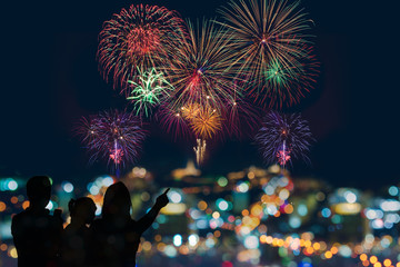 Fototapeta na wymiar The happy family looks celebration fireworks in the night sky 