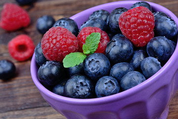 Blueberries with raspberries in a ceramic bowl on table