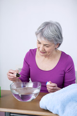 Senior woman preparing inhalation with essential oil