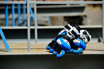 Roller inline skates in skate park on gray urban background