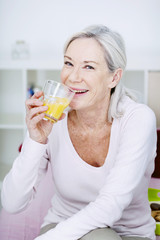 Senior woman drinking orange juice
