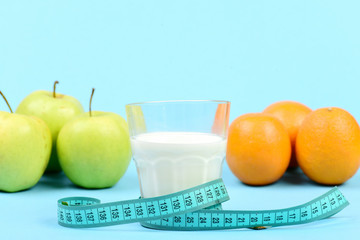 Fruit and glass of milk tied around with measuring tape