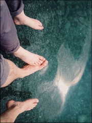 Couple sitting barefoot at the lake