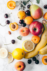 Summer fruits assorted on white marble background. Fresh raw food concept. Copy space