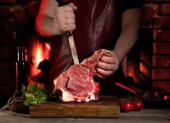 Man cutting raw beef meat.