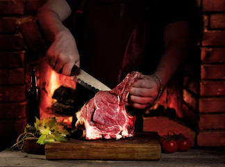 Man cutting raw beef meat.