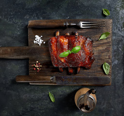 Delicious barbecued ribs seasoned with a spicy basting sauce and served with chopped fresh...