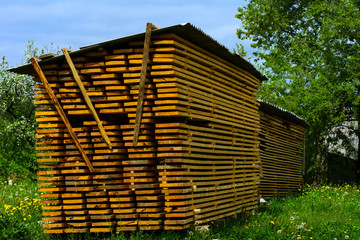 Planks stacked in a courtyard near a private house in the village