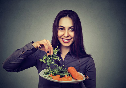 Happy woman with plate of vegetables