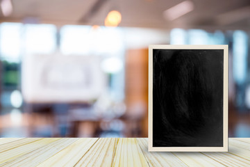 Blank chalkboard on table over blur restaurant with bokeh background, space for text, mock up, product display montage