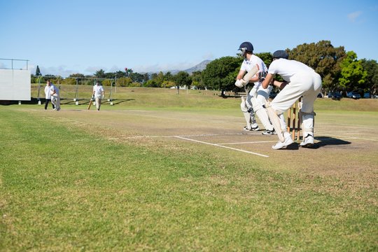 Cricket players playing match at field