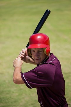 Confident baseball player hitting with bat