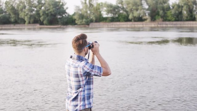 Young Man Standing and Taking Pictures in the Wild