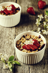 Strawberry blackberry crumble with oatmeal crispy crust on vintage rustic wooden table. Healthy breakfast. Summer baking. Diet. Selective focus. Toned image 