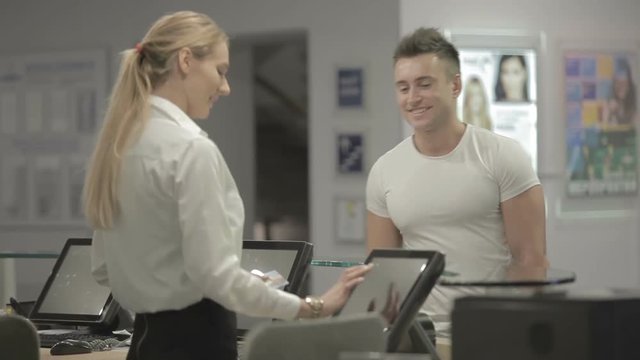 Beautiful hostesses gives the keys from the room in the hotel to the young man