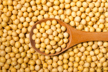 raw soybeans in the wooden spoon, top view