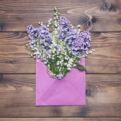 Lilac and lily valley flowers in envelope