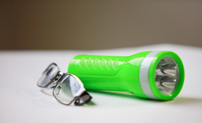 Black Eye Glasses and green flashlight on gray background