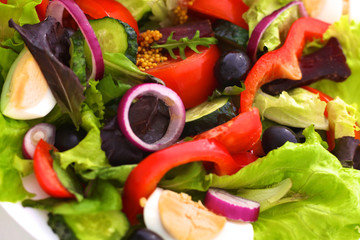 Salad of fresh vegetables and herbs on the table in the plate