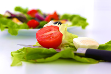 Fresh vegetables with a knife on the table for salad preparation