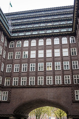 Detail of an Old Brick Building with White Windows and Balconies on the Upper Floors on a Cloudy Day