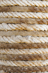 Fototapeta na wymiar Close up of alternating bands light and dark rope as it is wound tightly around a post