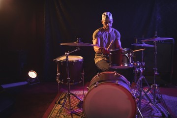 Obraz na płótnie Canvas Male drummer performing in nightclub
